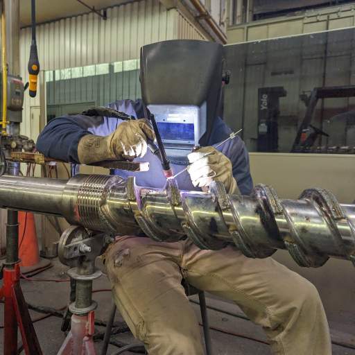 Re-establishing the profile of a mixing screw as part of a full remanufacture.