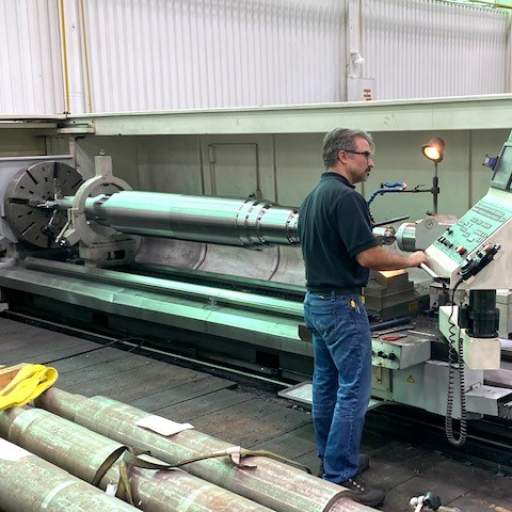 Large lathe turning a midsized turbine shaft