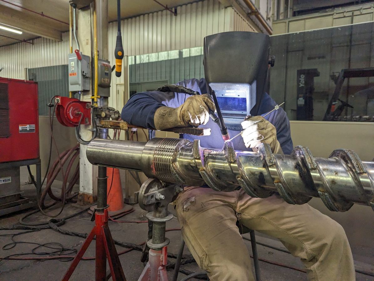 Weld overlay repair and hardfacing used for mixing screw profile restoration at HFW Industries.